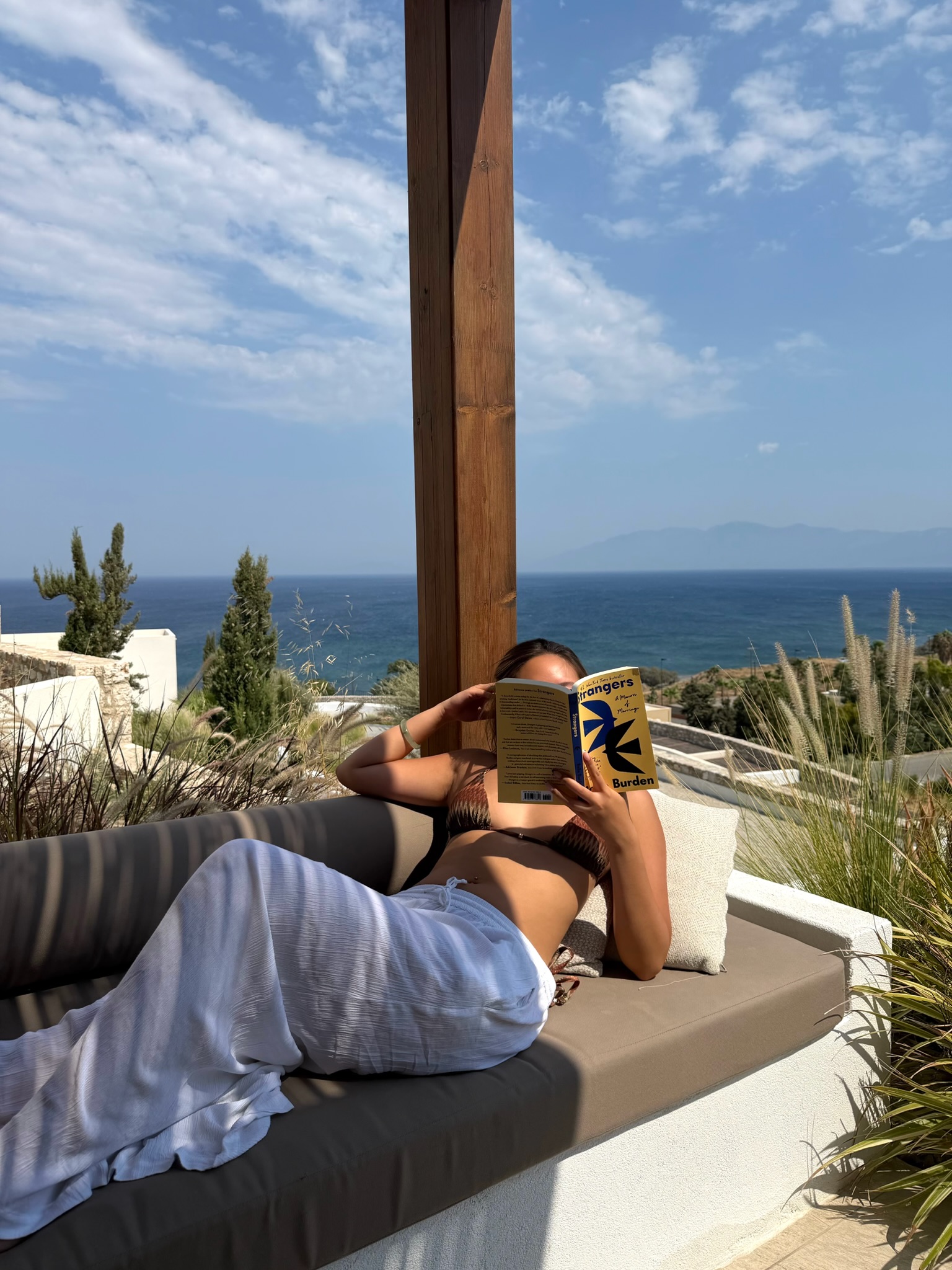 Reading on a terrace overlooking the sea at Koia